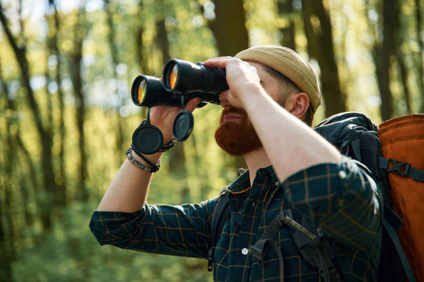 istock Using binoculars. Bearded man is in the forest at daytime 2153021604