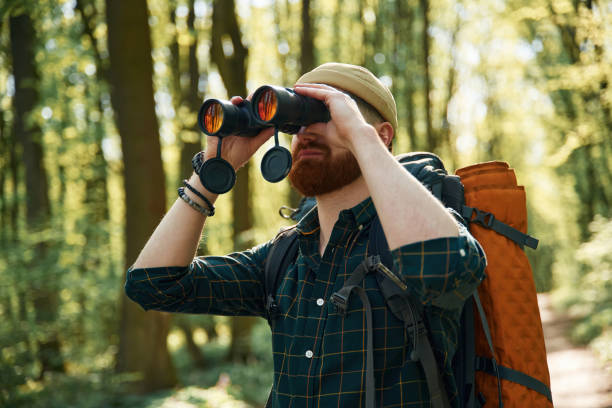 istock Using binoculars. Bearded man is in the forest at daytime 2153021636