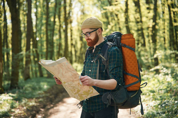 istock Reading the map, looking for a way. Bearded man is in the forest at daytime 2153021782