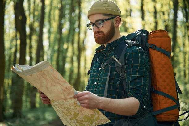 istock Reading the map, looking for a way. Bearded man is in the forest at daytime 2153021892