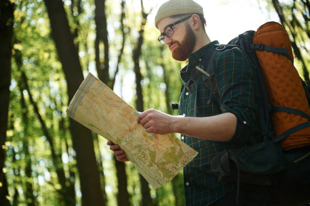 istock Big paper map. Bearded man is in the forest at daytime 2153021898