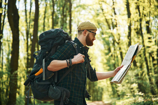 istock Big paper map. Bearded man is in the forest at daytime 2153022019