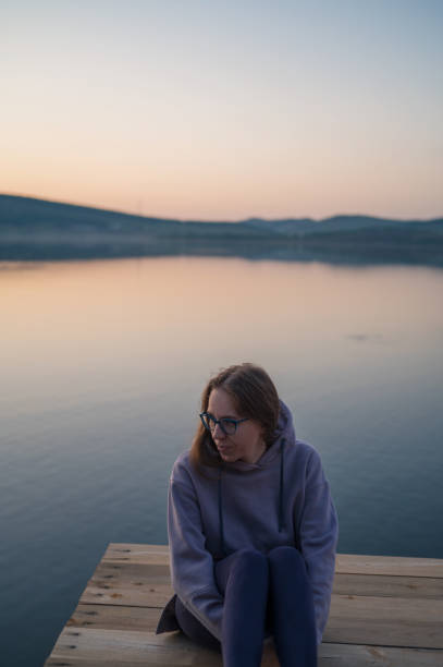 istock Woman sitting on the pier 2153022067
