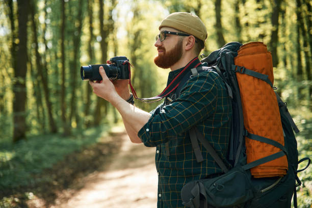 istock Photographer with camera. Bearded man is in the forest at daytime 2153022154