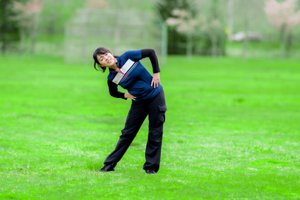 Warm up before going for a run, arm stretching at sunset or sunrise. Getting fit outdoor in the morning at a park
