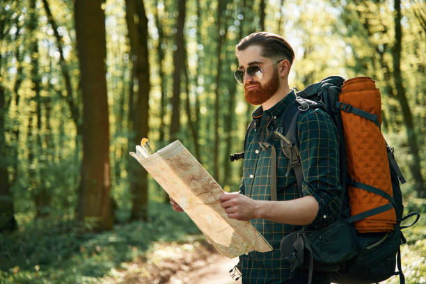 istock Using the map. Bearded man is in the forest at daytime 2153022566
