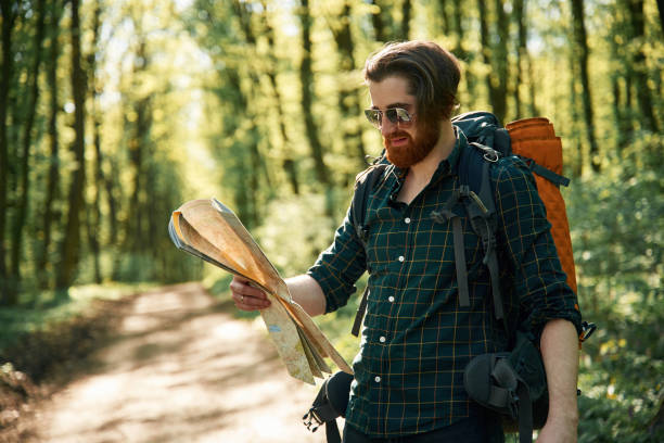 istock Using the map. Bearded man is in the forest at daytime 2153022627