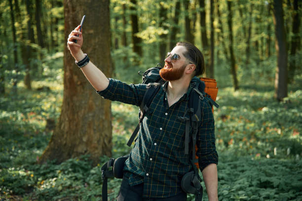 istock Phone in hand. Bearded man is in the forest at daytime 2153022730