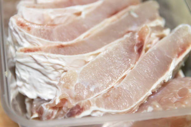 Unrecognizable chef cutting fresh pork meat - Close up shot