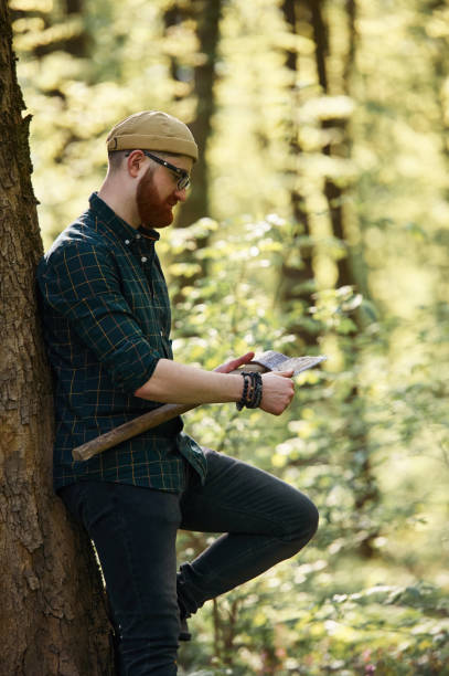 istock Woodcutter is standing. Bearded man is in the forest at daytime 2153023192