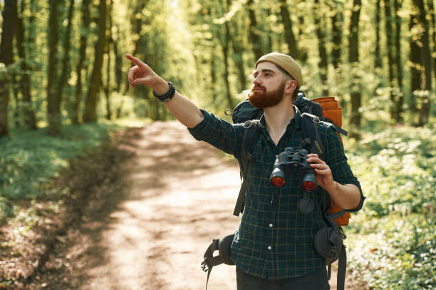 istock Discovering new place with binoculars. Bearded man is in the forest at daytime 2153023237