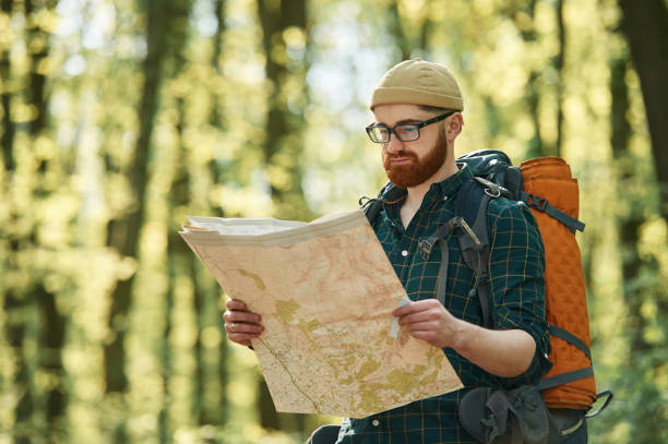 istock Focused on reading the map. Bearded man is in the forest at daytime 2153023314