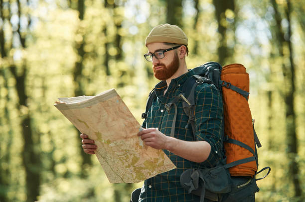 istock Focused on reading the map. Bearded man is in the forest at daytime 2153023346