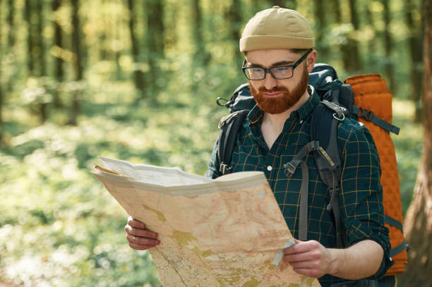 istock Focused on reading the map. Bearded man is in the forest at daytime 2153023349