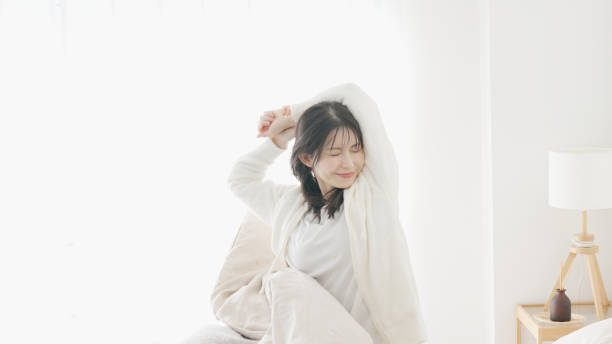 a woman who wakes up and stretches - 生活習慣 女性 ストックフォトと画像