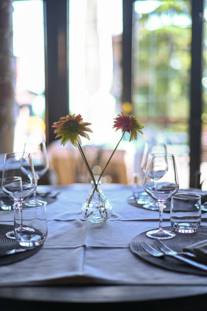 istock Intimate dining setup with flowers and glassware, soft focus for a serene ambiance 2153024040