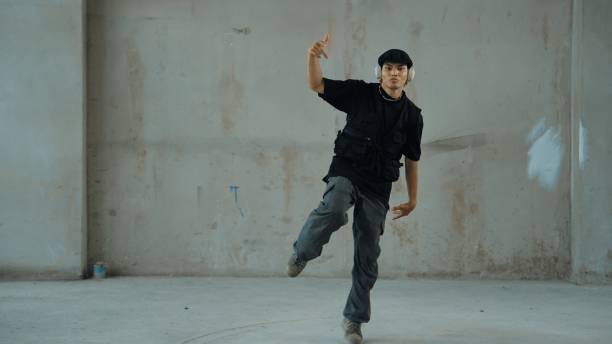 istock Hipster practicing break dancing while listening music from headphone. Endeavor. 2153026795