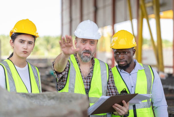 istock Engineer and foreman worker team checking project at precast concrete factory site, Engineer and builders in hardhats discussing on construction site 2153027058