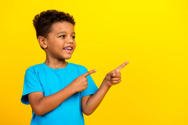 istock Portrait of mixed race multiethnic multinational schoolboy look directing at discount empty space isolated on vivid yellow background 2153027632