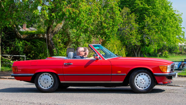 Stoke Goldington,UK - May 11th 2024: 1987 red Mercedes Benz 300 sl  classic car driving on a British road