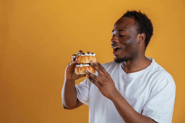 istock Tasty little cakes. Black guy is against yellow background 2153028949