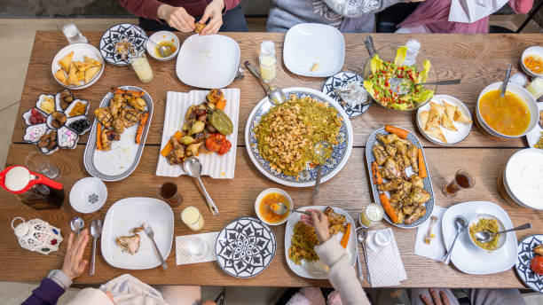 istock A Muslim family gathers around a rectangular table, sharing a heartwarming meal together, with members of various ages adding to the warmth and joy of the occasion 2153029270