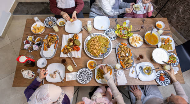 istock A Muslim family gathers around a rectangular table, sharing a heartwarming meal together, with members of various ages adding to the warmth and joy of the occasion 2153029527