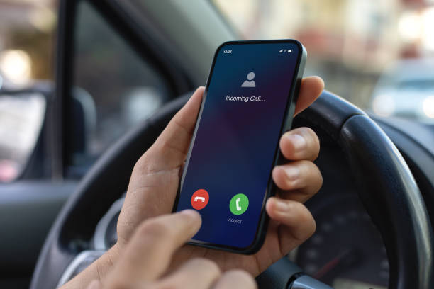istock Man hand hold phone incoming call background steering wheel car 2153035447