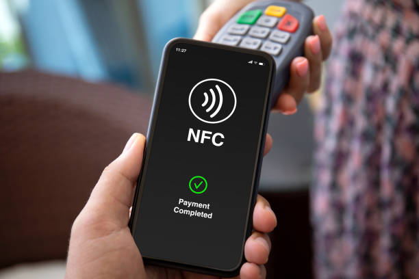 istock Man hand phone pay wireless technology nfc via pos terminal 2153035729