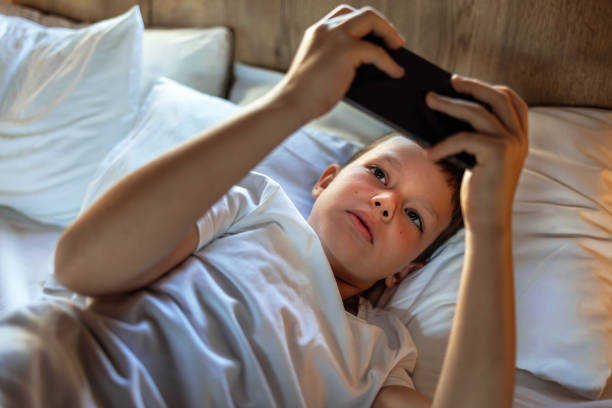 istock Little boy playing online games on mobile phone. 2153035893
