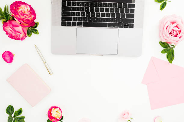 istock Office desk with laptop, pink roses and pink diary on white background. Flat lay. Top view. Freelance concept with copy space 2153038426