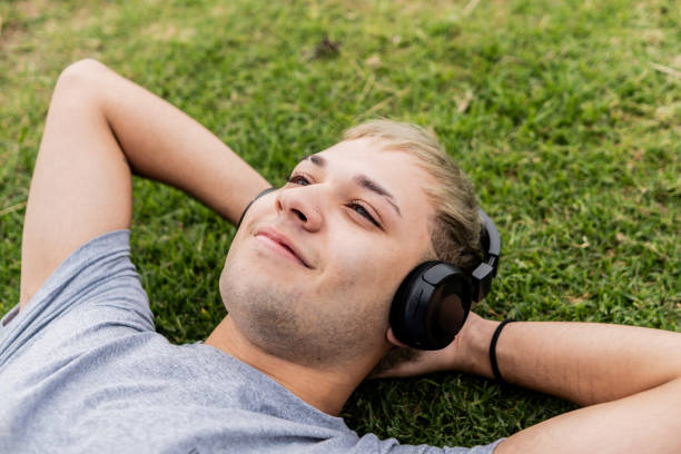 istock Young man contemplating lying on grass outdoors 2153038562