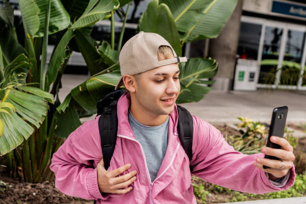 istock Young man using mobile phone and waiting outside the airport 2153038601