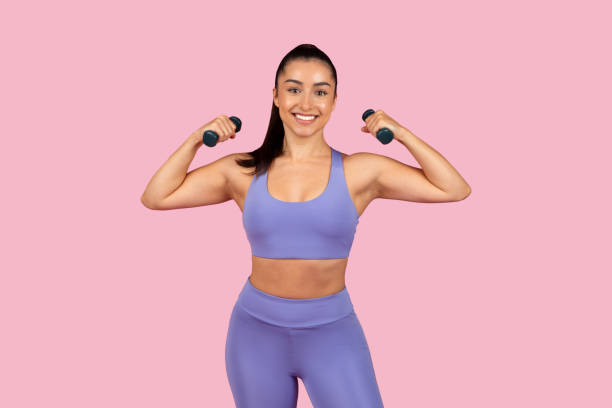 istock Strong woman flexing muscles with dumbbells 2153042777
