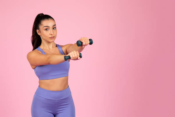 istock Athletic woman lifting dumbbells with focus 2153042798