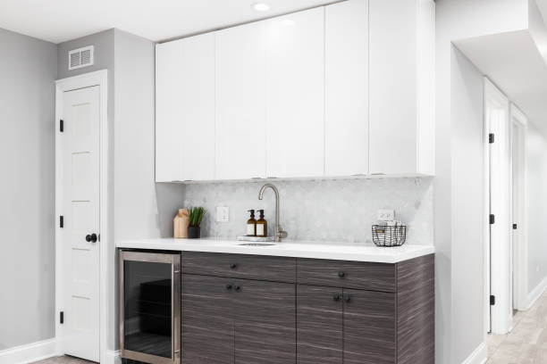 istock A wet bar with wood and white cabinets and a hexagon tile backsplash. 2153043259