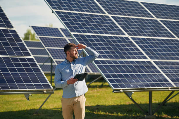 istock Holding laptop. Engineer with photovoltaic solar panels outdoors at daytime 2153046149