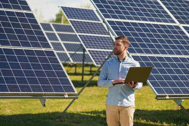 istock Holding laptop. Engineer with photovoltaic solar panels outdoors at daytime 2153046151