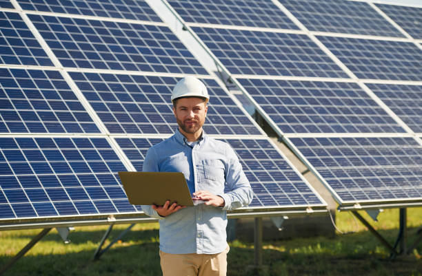 istock With laptop. Engineer with photovoltaic solar panels outdoors at daytime 2153046221