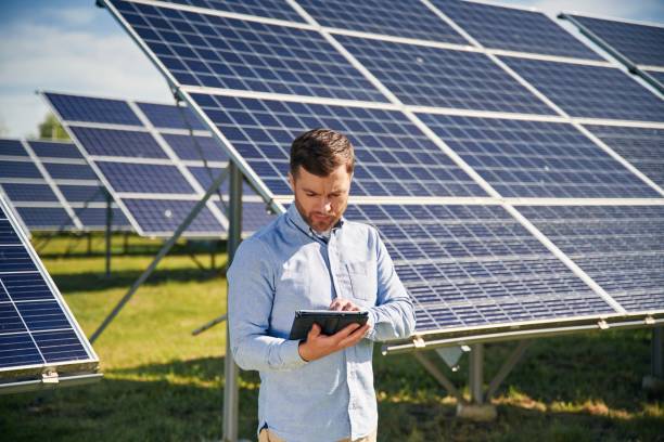 istock Digital tablet in hand. Engineer with photovoltaic solar panels outdoors at daytime 2153046950