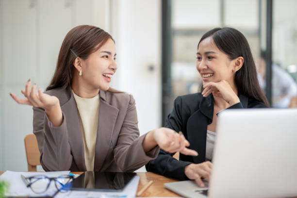istock Two business colleagues talking share ideas while meeting remotely with team on laptop. 2153047010