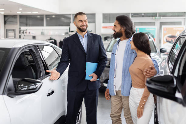 istock Salesman explaining car features to indian couple 2153047273