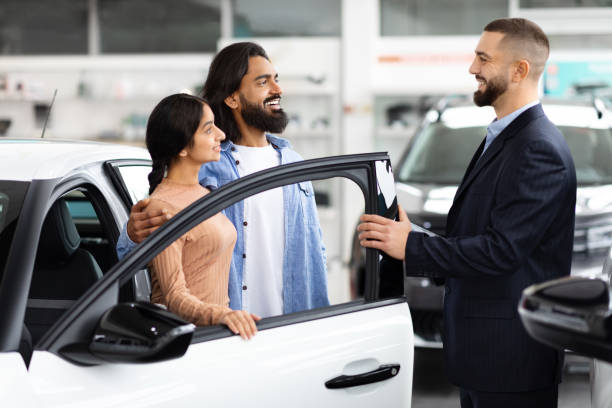 istock Salesman opening car door for customers 2153047311