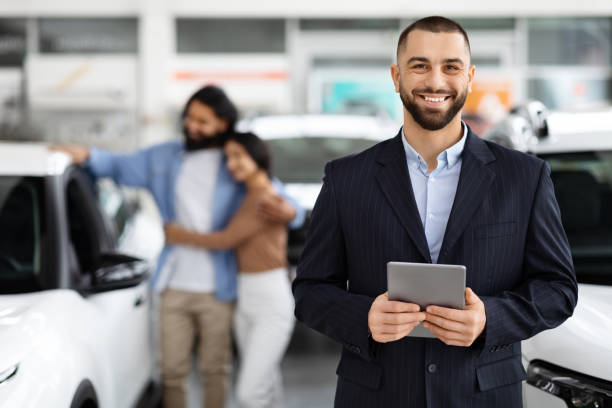 Smiling salesman with clients in the background