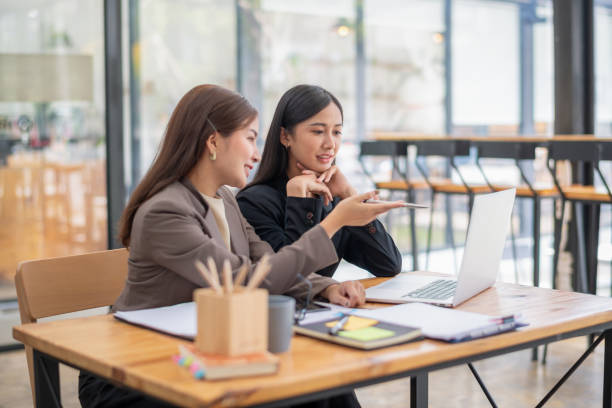 istock Two business colleagues talking share ideas while meeting remotely with team on laptop. 2153047560