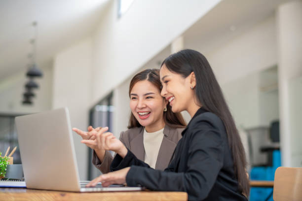 istock Two business colleagues talking share ideas while meeting remotely with team on laptop. 2153047588