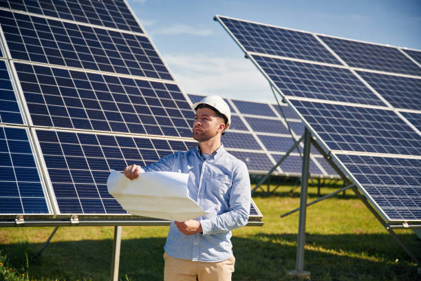 istock Reading the plan on paper. Engineer with photovoltaic solar panels outdoors at daytime 2153047597