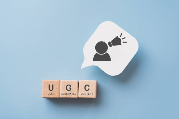 For user-generated content concept.(UGC) Online marketing. Customer create content on social media . Wooden cube blocks with UGC text and abbreviation , white speech bubble paper with icon