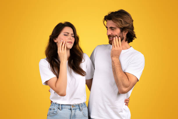 istock A concerned young woman and a man touch their cheeks with pained expressions 2153049469