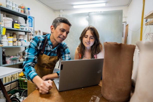 istock Coworkers using laptop at ceramics store 2153049769